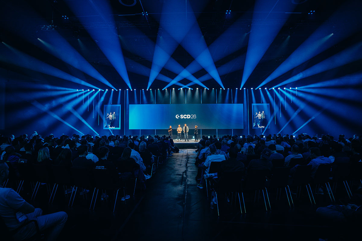 Große LED-Bühne mit Lichtinszenierung und Publikum beim Shopware Community Day im Confex Köln, technisch umgesetzt von müllermusic Veranstaltungstechnik.